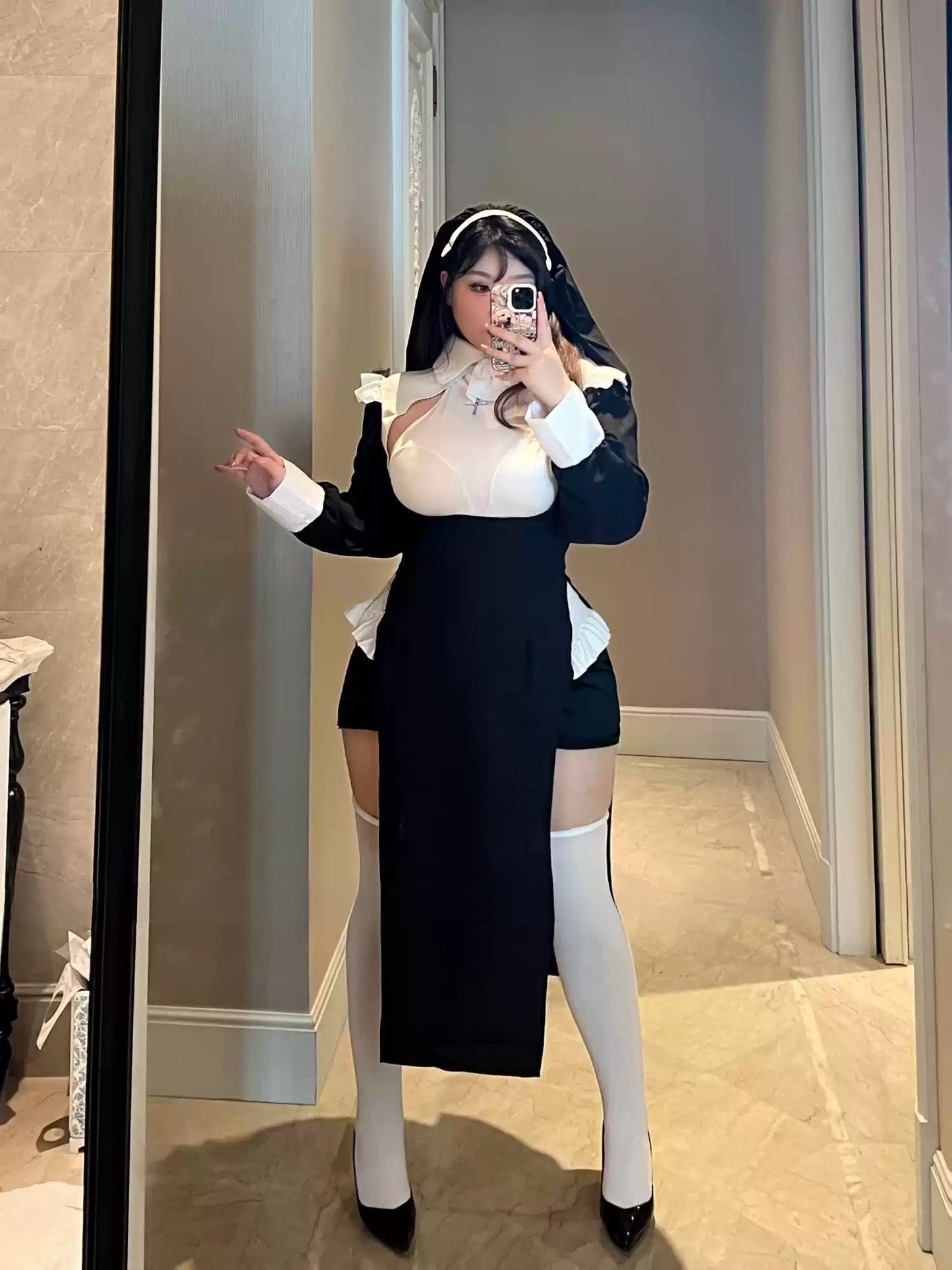 Full-body mirror selfie of woman in nun-themed lingerie costume with white stockings.