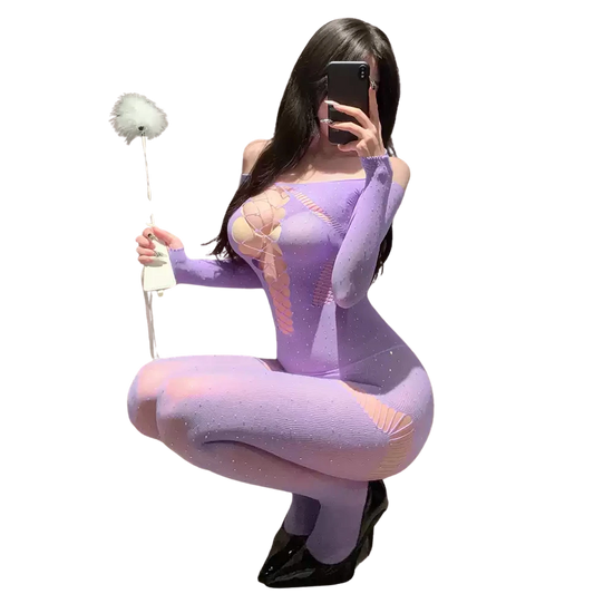 Model wearing a sexy lavender bodystocking lingerie with lace-up front and glitter details, holding a feather duster.