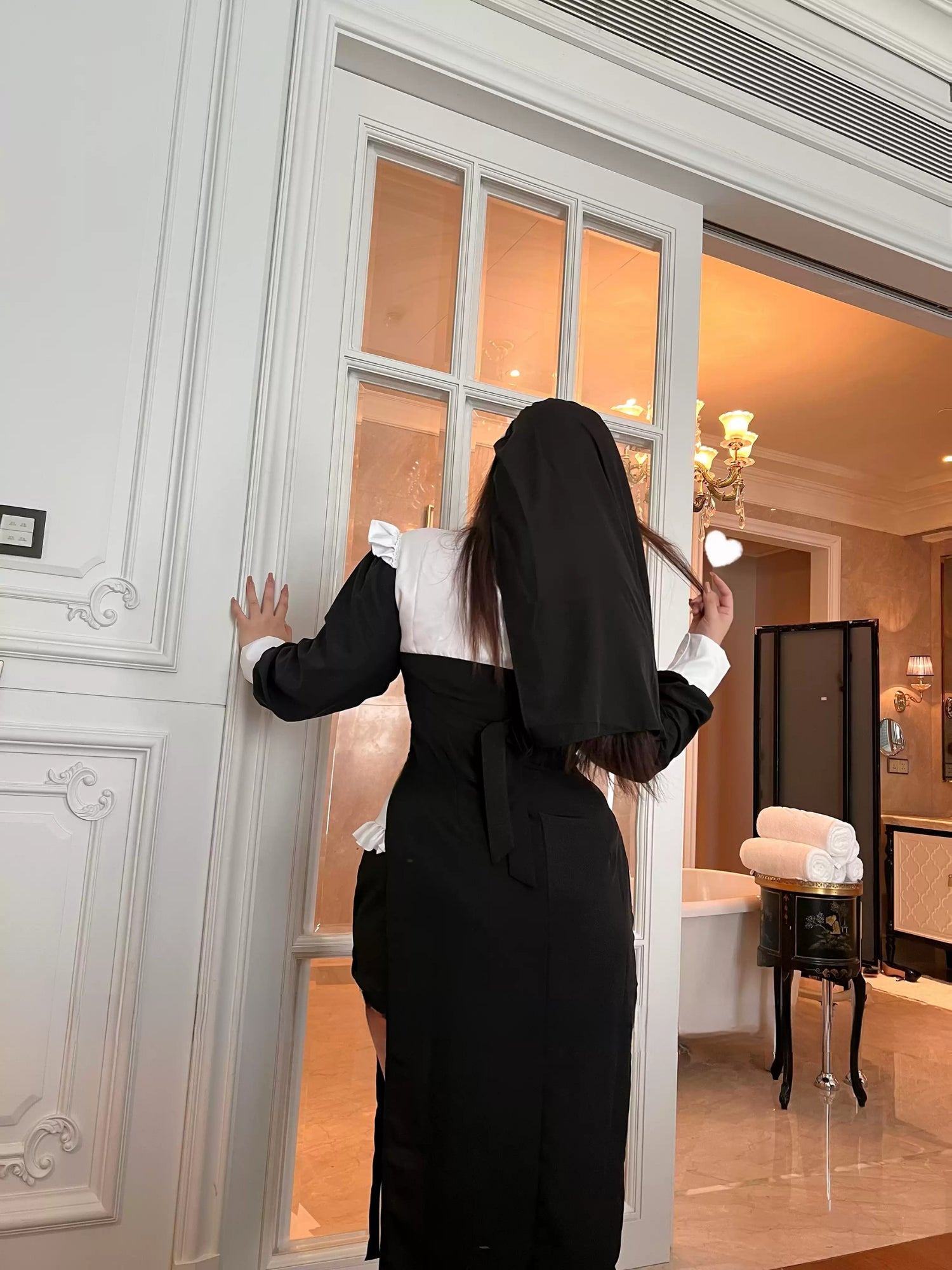 Rear view of nun cosplay costume showing black veil and back waist tie detail.