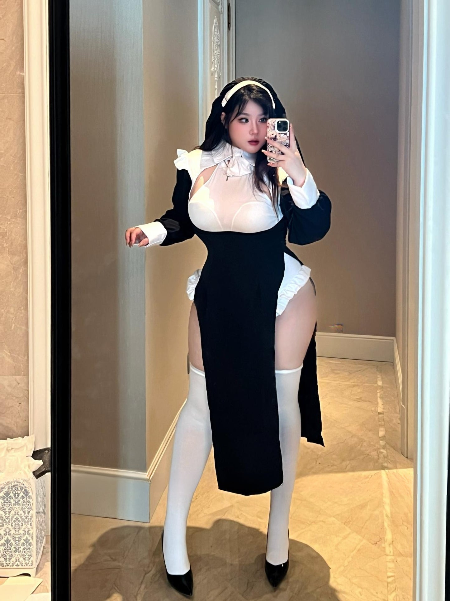 Woman modeling nun-style lingerie costume with sheer bust and long sleeves, standing front-facing.